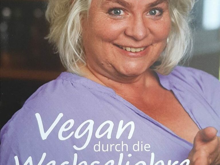 Titelbild: Vegan durch die Wechseljahre von Andrea Panz. Porträt der Autorin in lilaner Bluse mit einem Teller in der Hand.