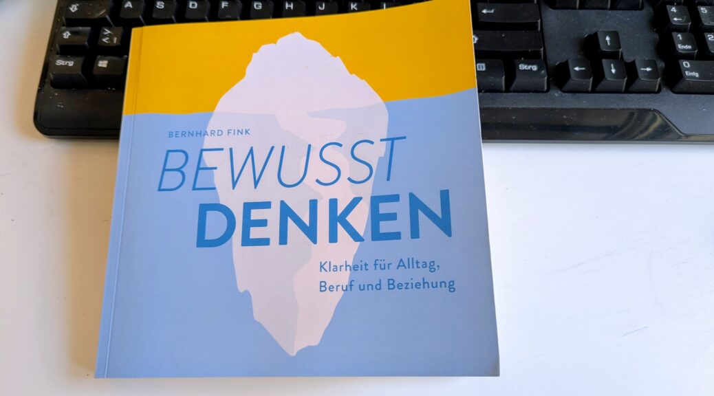 Das Buch "bewusst denken" von Bernhard Fink - Coverabbildung und im Hintergrund eine PC-Tastatur